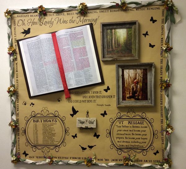 a bulletin board with pictures and an open book on it's side, decorated with butterflies