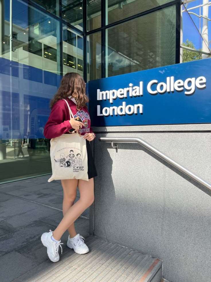 a girl is leaning against the wall with her purse