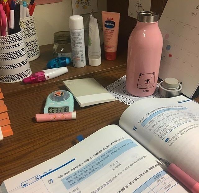 an open book sitting on top of a wooden desk next to a calculator