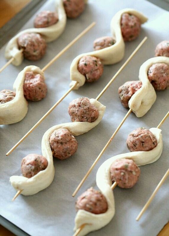 meatballs on skewers are being prepared to be eaten