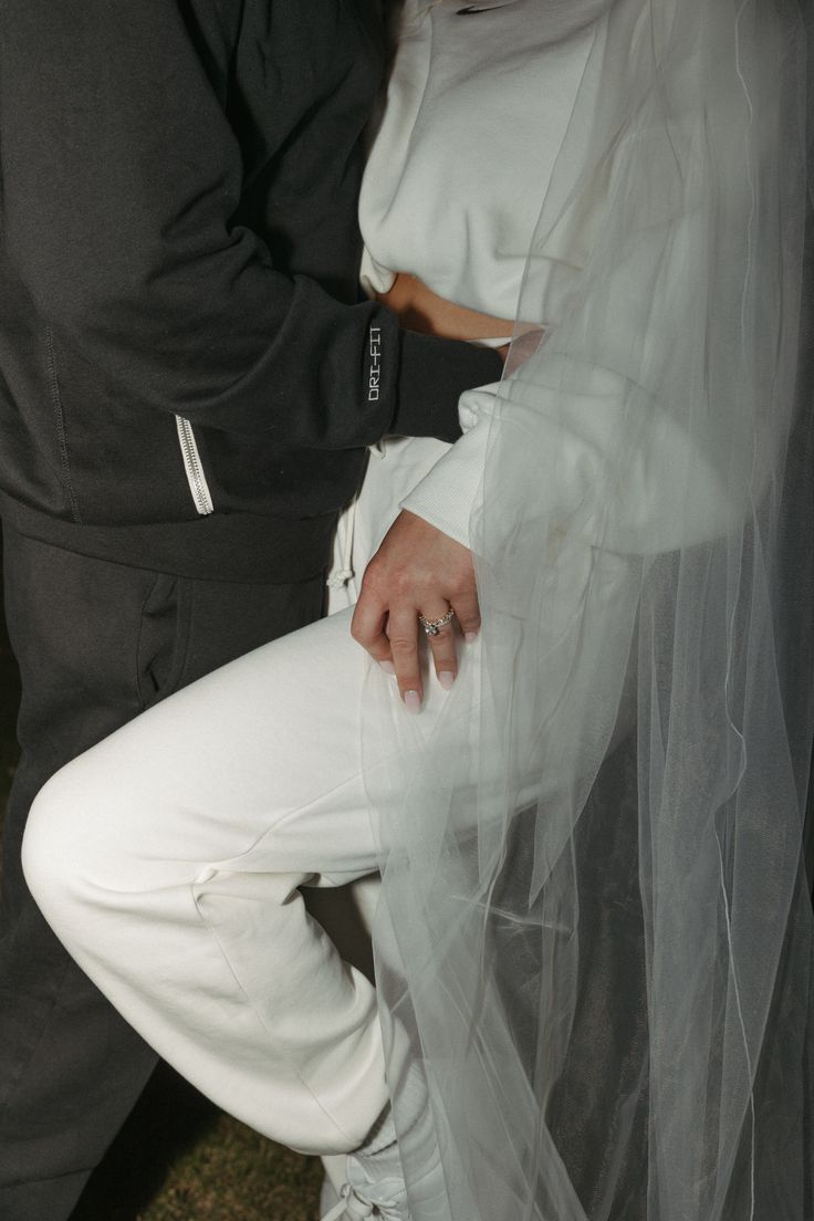 a man and woman dressed in white posing for the camera with their arms around each other