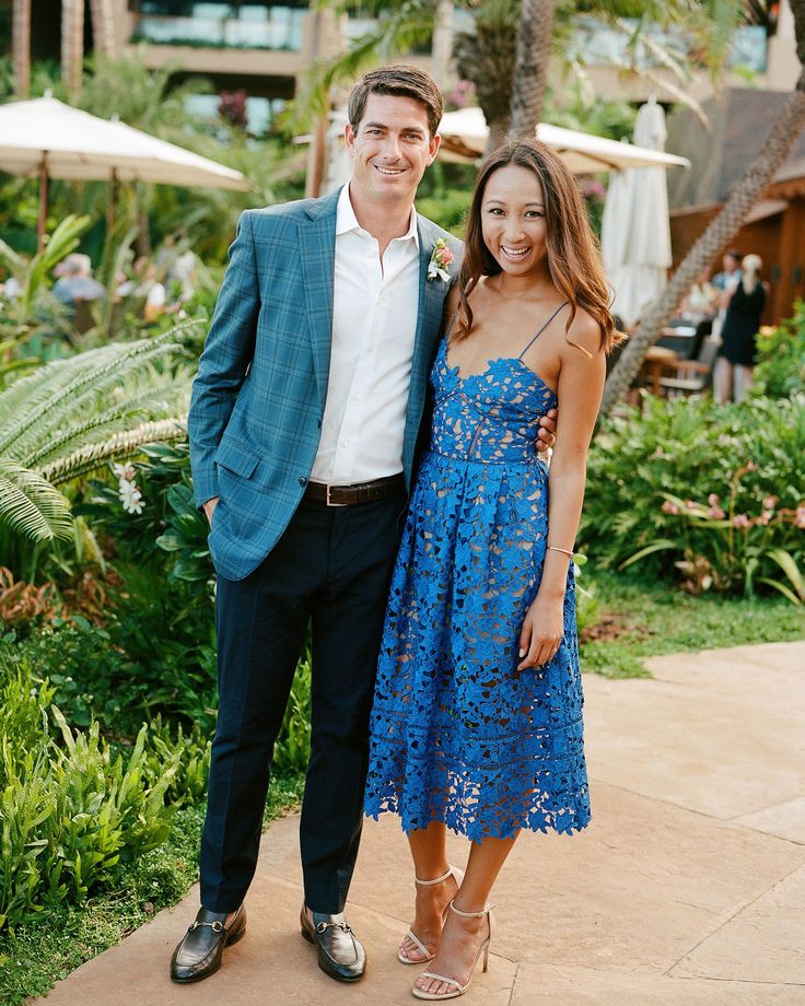 a man standing next to a woman in a blue dress