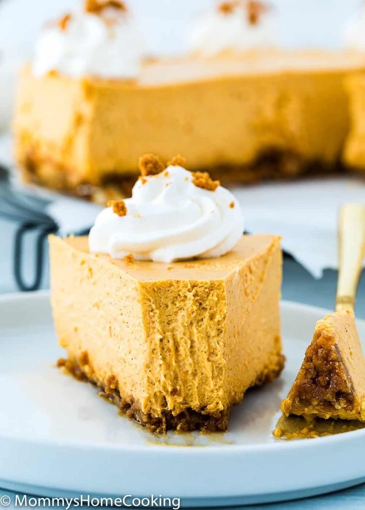 a piece of pumpkin cheesecake on a plate with a fork and another slice in the background