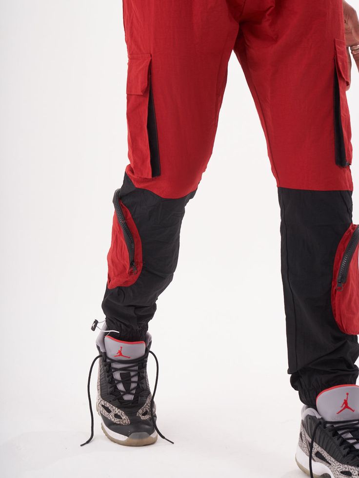 Double-color red and black joggers with four functional cargo pockets on the knees and elastic ankles. FEATURES Slim Fit Made up of 95% Cotton and 5% Elastane Jogger comfort Drawstring waist SIZE GUIDE Model's height and weight: 6"1 feet & 180 lbs. (185 cm & 82 kg ) Model wears size: L Sportswear Cargo Pants With Side Pockets For Outdoor, Sportswear Cargo Pants With Side Pockets For Outdoor Activities, Black Cargo Jeans For Outdoor Activities, Functional Cargo Jeans With Side Pockets For Outdoor, Functional Cargo Jeans With Side Pockets For Outdoor Activities, Sporty Outdoor Cargo Jeans, Sporty Cargo Jeans For Outdoor, Sporty Cargo Style Joggers For Streetwear, Sportswear Joggers With Cargo Pockets For Streetwear