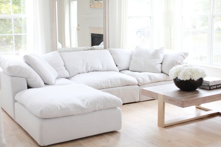 a large white couch sitting in a living room next to a coffee table