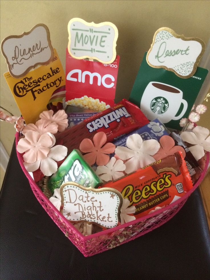 a pink heart shaped basket filled with candy and snacks