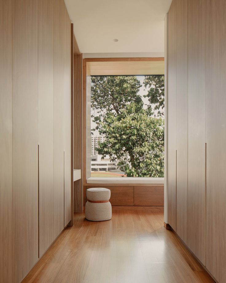 an empty room with wooden flooring and large window overlooking the trees outside in front of it