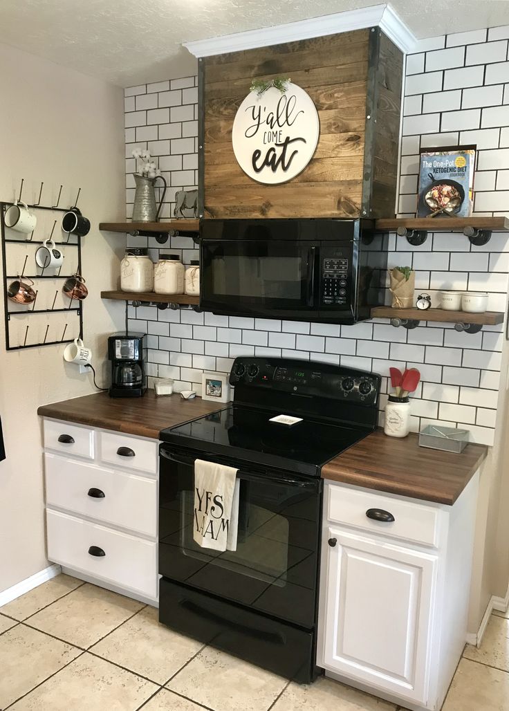 a black stove top oven sitting inside of a kitchen next to white cabinets and counters