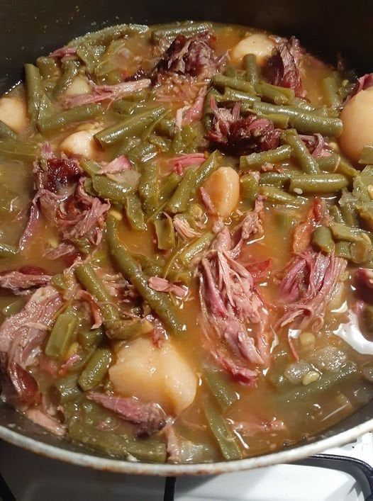 a pot filled with meat and green beans