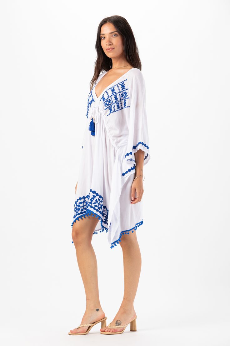 Elevate your beach wardrobe with our Mykonos Mini Dress. This exquisite embroidered coverup allows you to embrace the artistry of seaside fashion. With its intricate detailing and effortless charm, this coverup is sure to make you feel like a beach goddess wherever your adventures take you. Details: 100% Rayon Hand Wash in Cold Water and Lay Flat to Dry Features: Unlined, V-neckline, Embroidered detail, Tassel tie closure to cinch waist for an adjustable fit, Sides drape lower, Billowing short s Embroidered Kaftan For Beach Cover-up, Blue Boho Dress For Beach Cover-up, Summer Kaftan With Tassels For Spring, Summer Embroidered Dresses For Beach Season, Summer V-neck Embroidered Kaftan, Beach Vacation Dresses With Floral Embroidery, Embroidered Tunic For Spring Vacation, Floral Embroidered Tunic For The Beach, Spring Beachwear Kaftan With Tassels