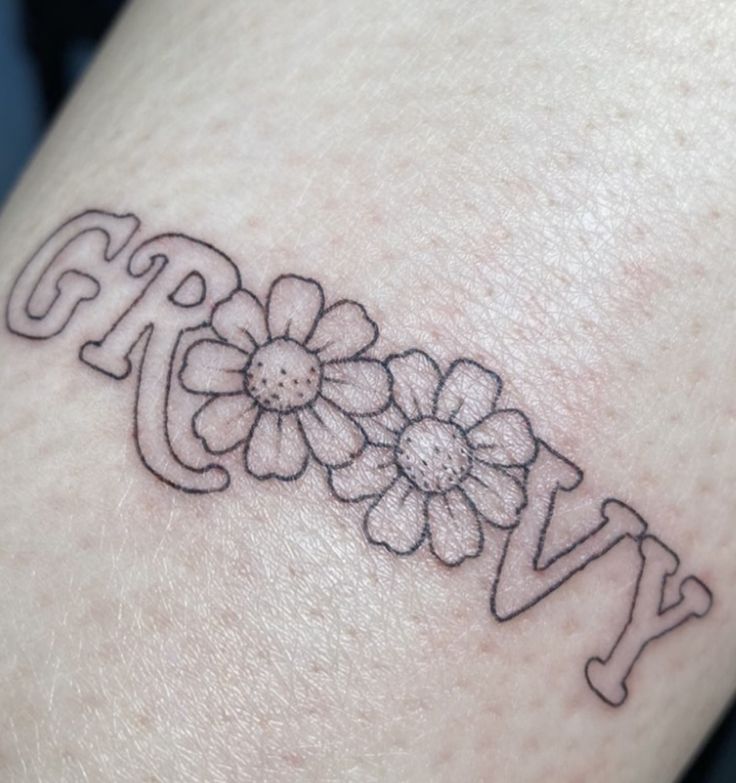 a woman's arm with flowers on it and the word joy written in cursive writing