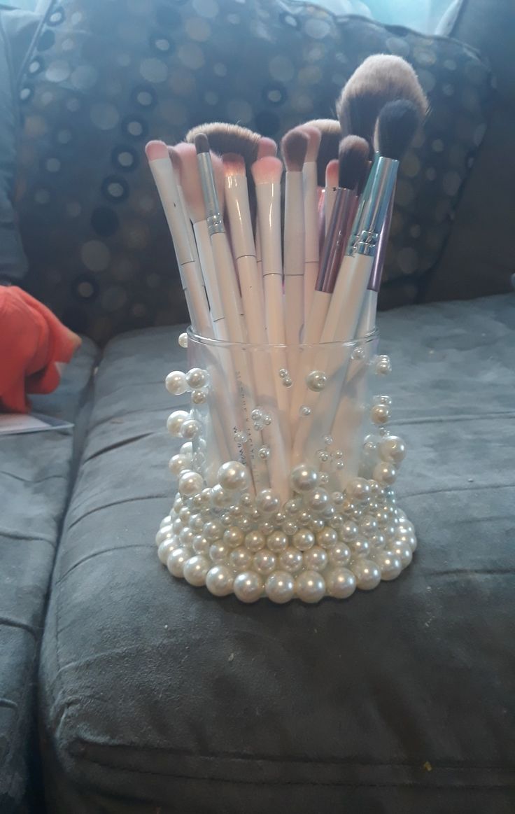 a bunch of makeup brushes sitting on top of a table next to a couch in a living room