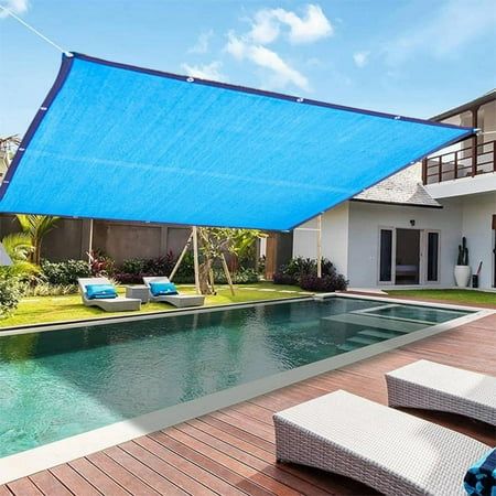 an outdoor swimming pool with blue shade covering it