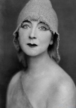 an old black and white photo of a woman with a hat on it's head