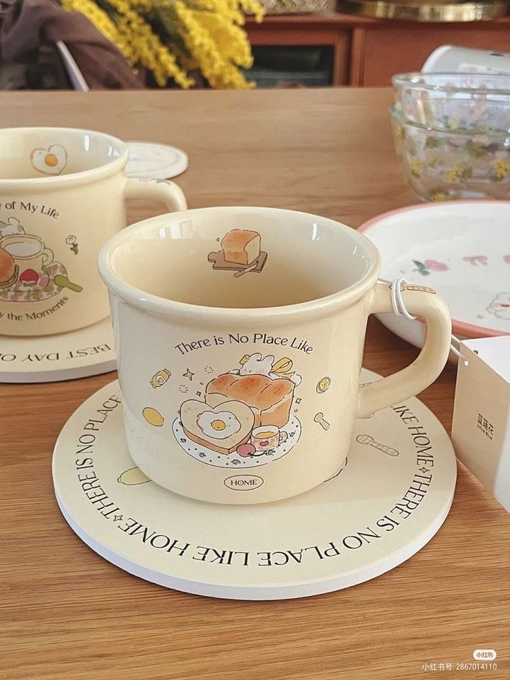 two coffee cups and saucers sitting on a table