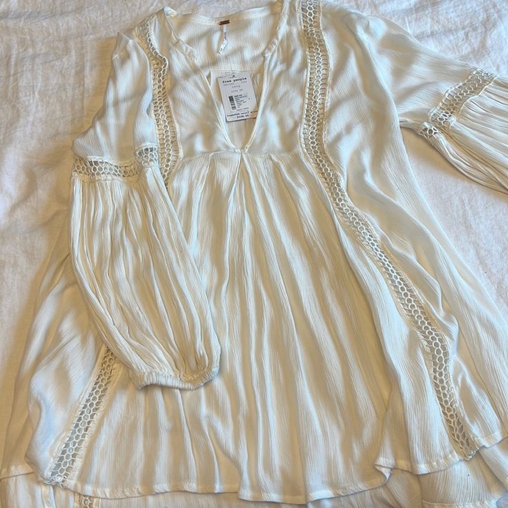 Long, Flowy Bell Sleeve Tunic. 100% Rayon. Off-White Ivory Color. New With Tags But Purchased With Slight Discoloration On Back Neckline (See Second Photo). Flowy Cream Blouse For Beach, Casual Cream Blouse For Vacation, Summer White Blouse With Lace Trim, Flowy Cream Blouse For The Beach, White Bohemian Blouse For Brunch, White Lace Trim Blouse For Summer, White Summer Blouse With Lace Trim, White Feminine Blouse For Vacation, Feminine White Blouse For Vacation