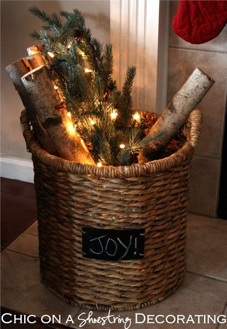 a christmas tree in a basket with lights on the top and some logs sticking out of it