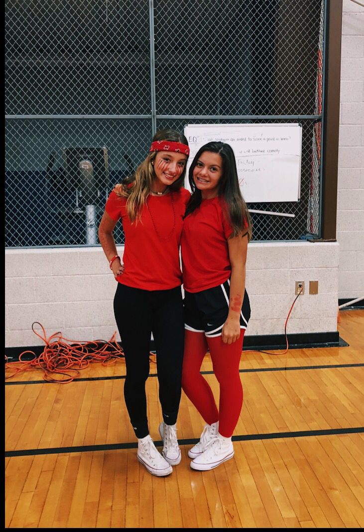 two young women standing next to each other on a basketball court