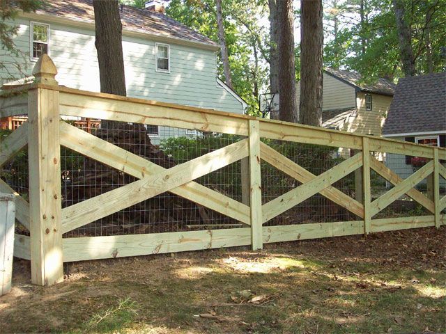 a wooden fence in front of a house with a gate on the top and bottom