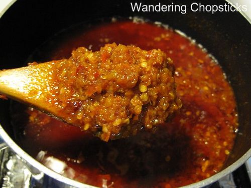 a spoon full of chili sauce on top of a stove