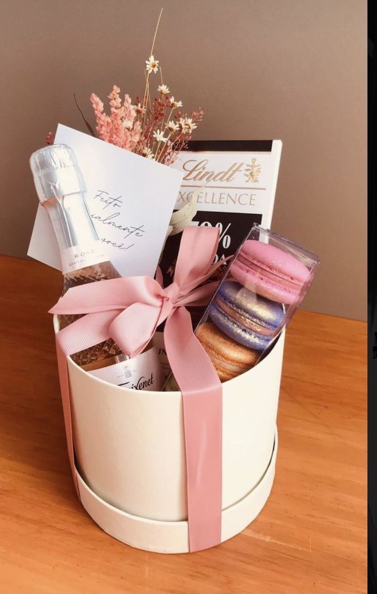 a white box filled with lots of different types of food and confection on top of a wooden table