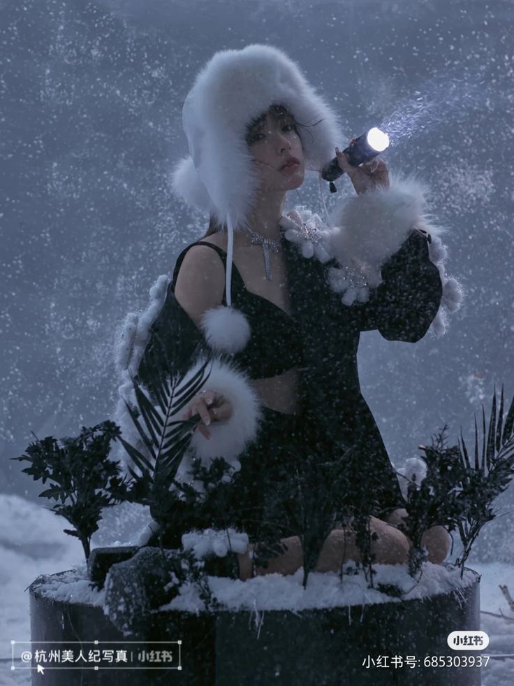 a woman wearing a fur hat and holding a cell phone in her hand while sitting on top of a potted plant