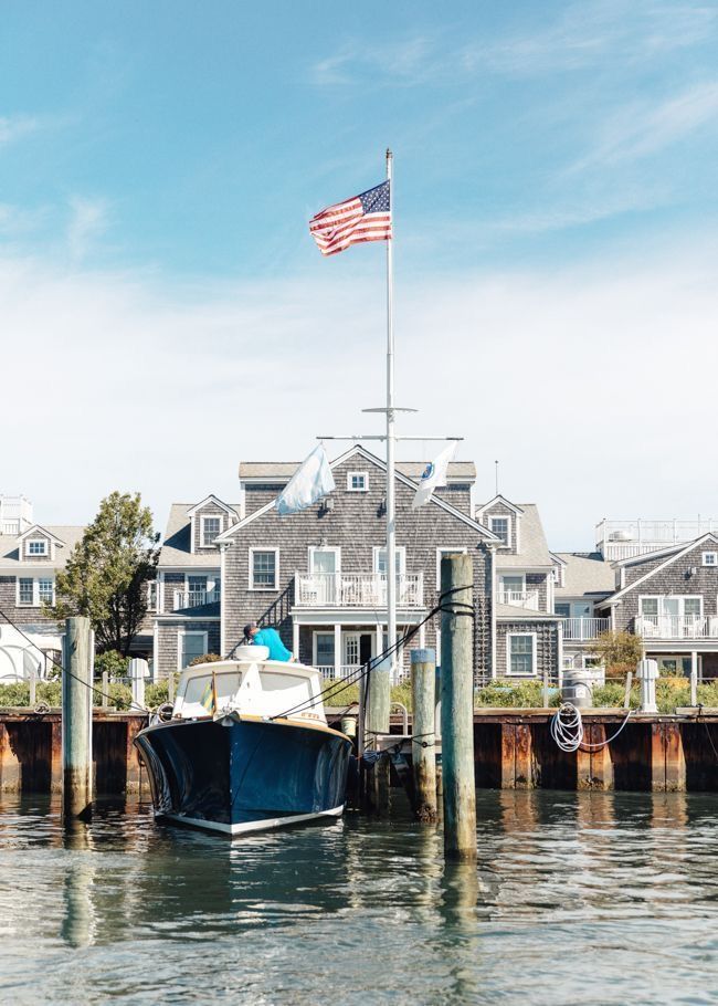 a boat is docked in the water next to some houses with an american flag on it