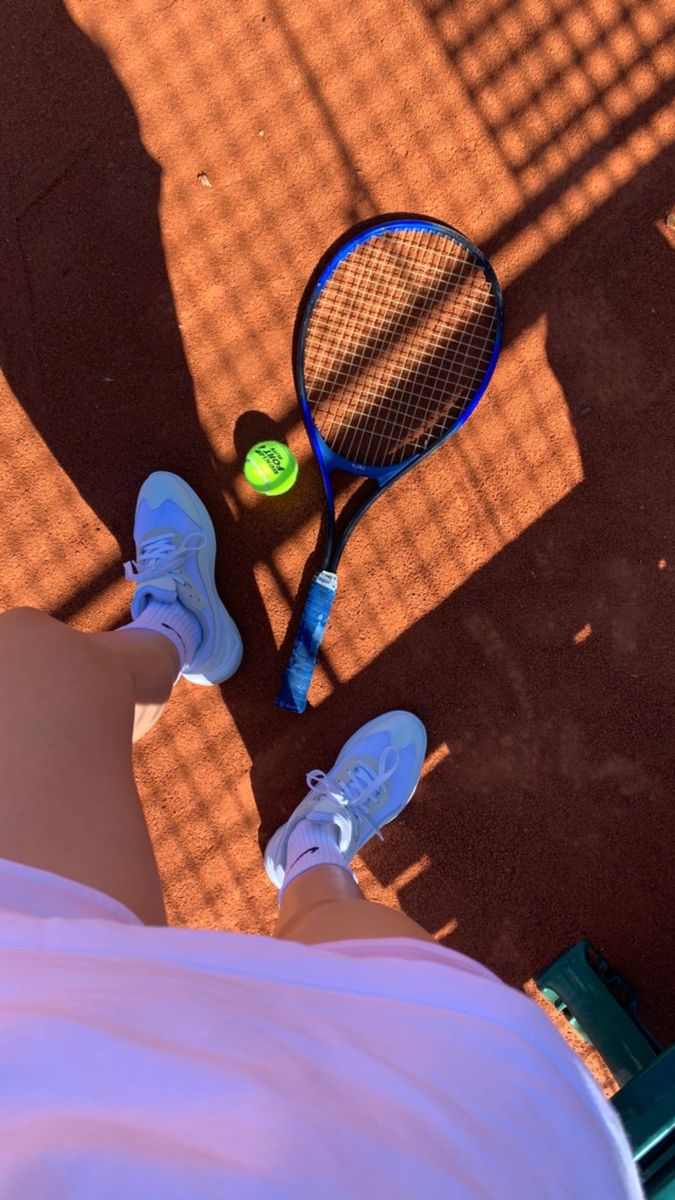 a tennis player's feet and racket on the court