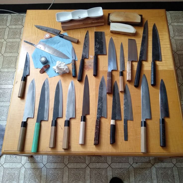 many knives are laid out on a table