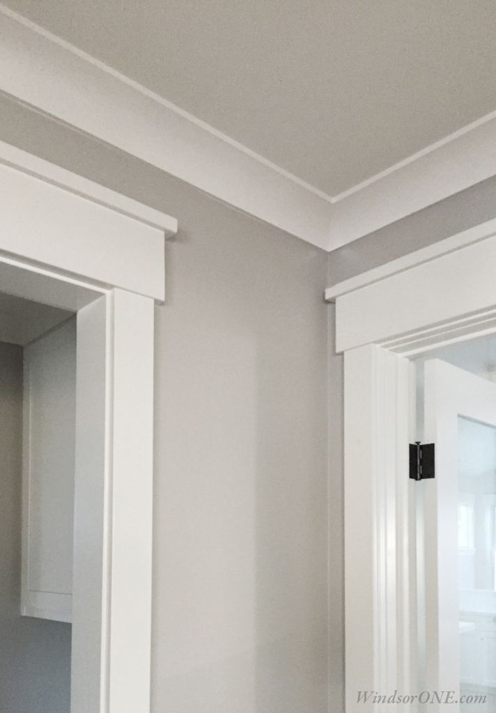 an empty bathroom with white cabinets and gray walls