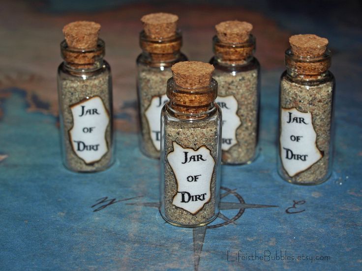 seven jars with labeled jar of dirt sitting on top of a table