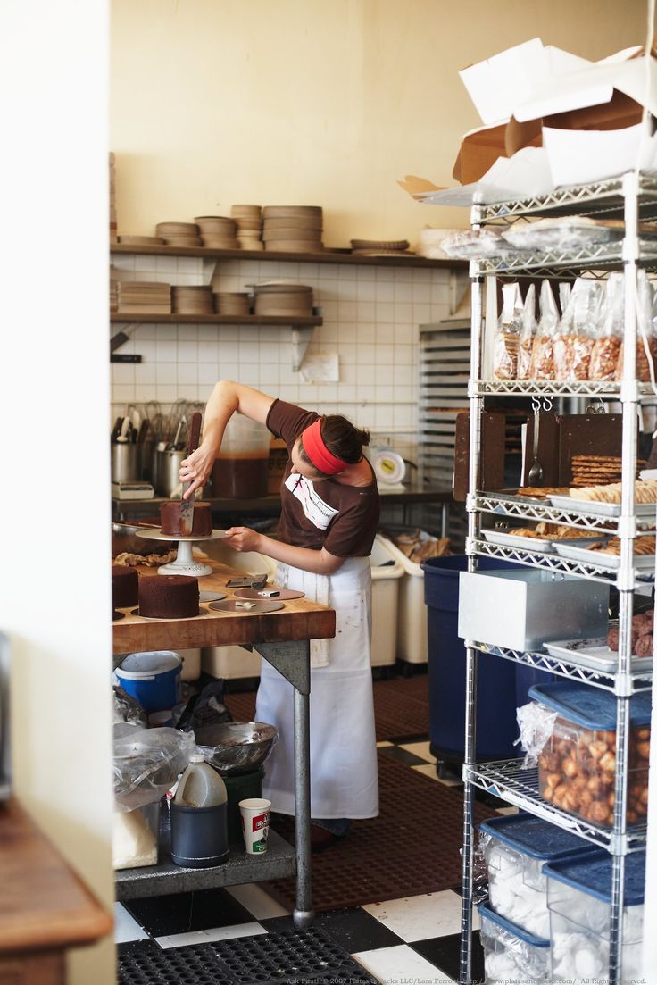 a woman is working in a bakery kitchen