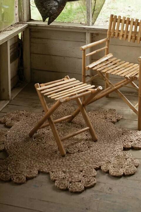 two wooden chairs sitting on top of a rug in front of a window next to a chair