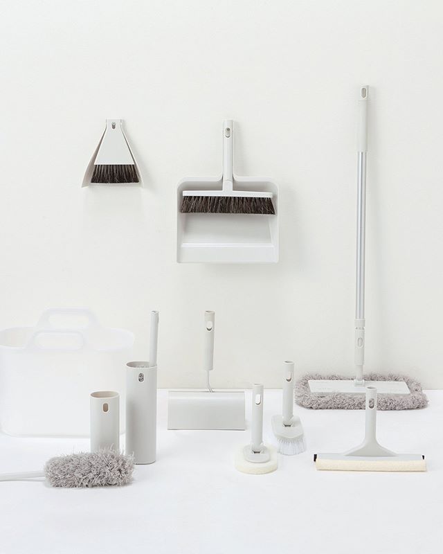 several cleaning products are arranged on a white surface, including brooms and mop heads