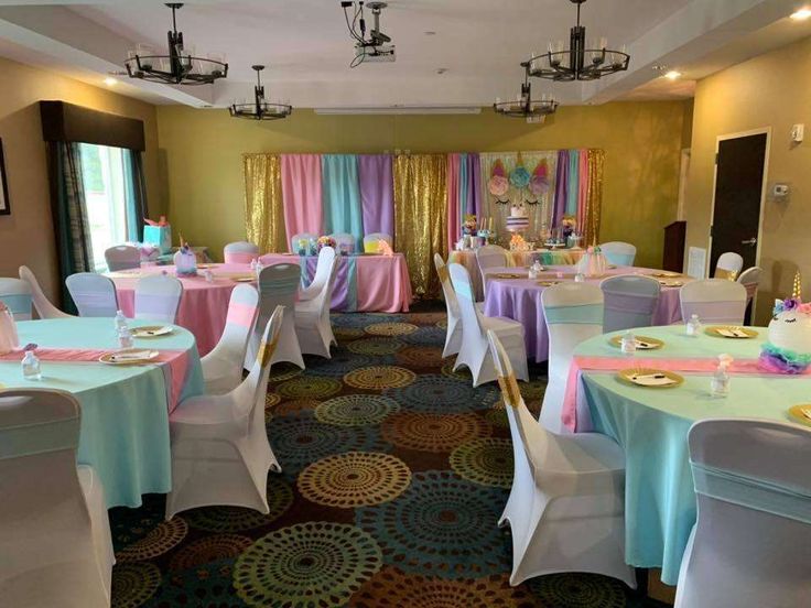 a banquet room with tables and chairs covered in colorful tablecloths