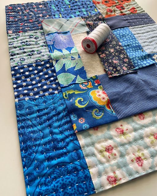 a close up of a piece of fabric on a table with some spools of thread