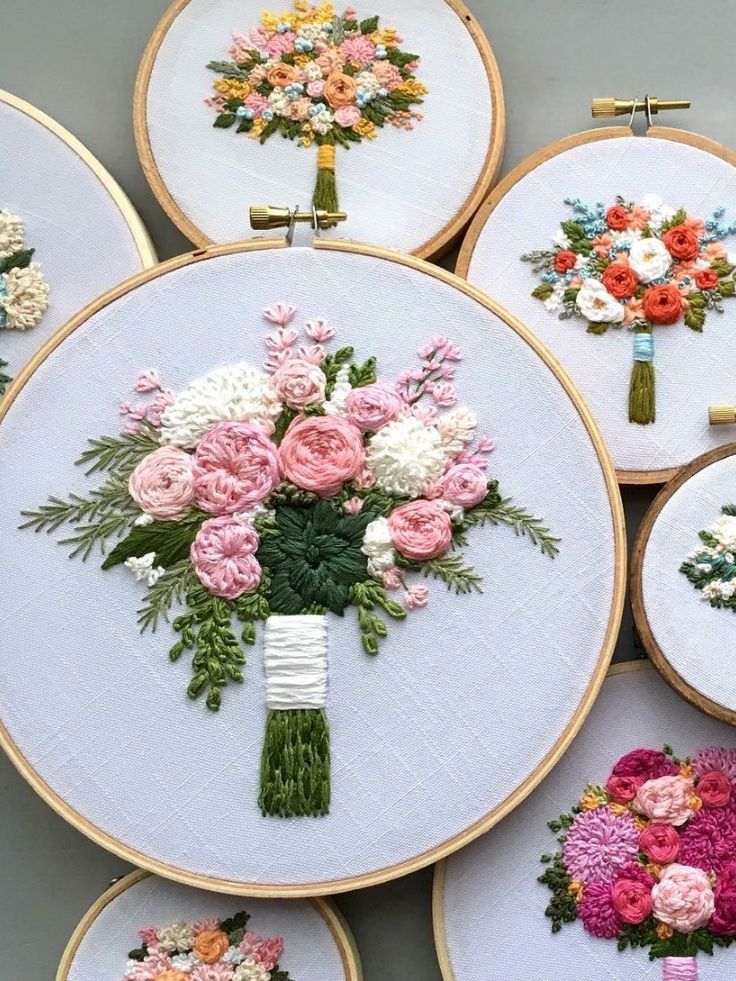 embroidery flowers are arranged in rows on the hoop with pins and needles to make them look like bouquets