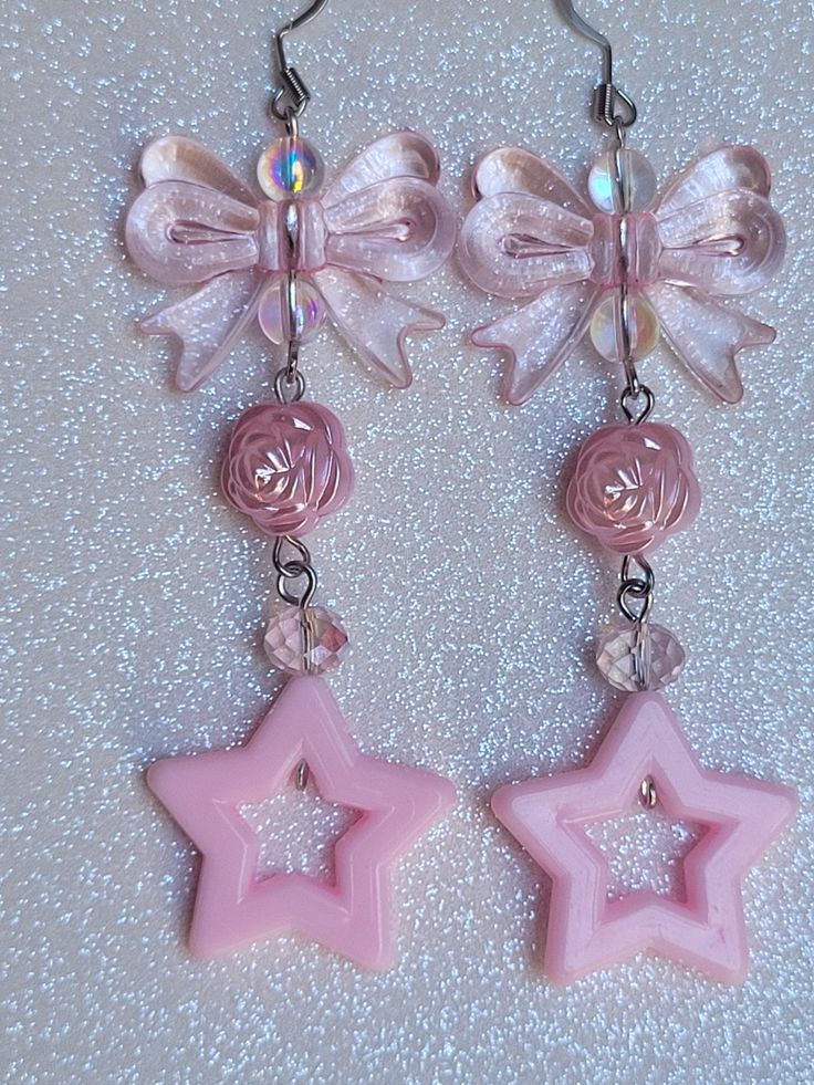 These earrings are made with acrylic baby pink stars, pink acrylic bow knots, pink acrylic rose beads, baby pink glass crystal beads, and little iridescent glass beads. They are approximately 3-1/2 inches in length. The ear wires are easily adjustable :) Disco Earrings, 1980's Style, Coquette Jewelry, Acrylic Rose, Star Drop Earrings, Fantasy Earrings, Rose Beads, Celestial Earrings, Retro Earrings