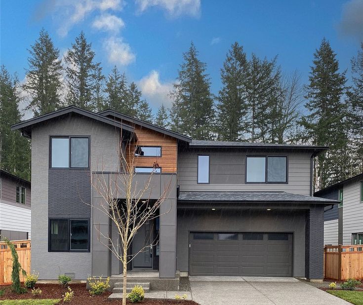 a two story house with lots of trees in the background