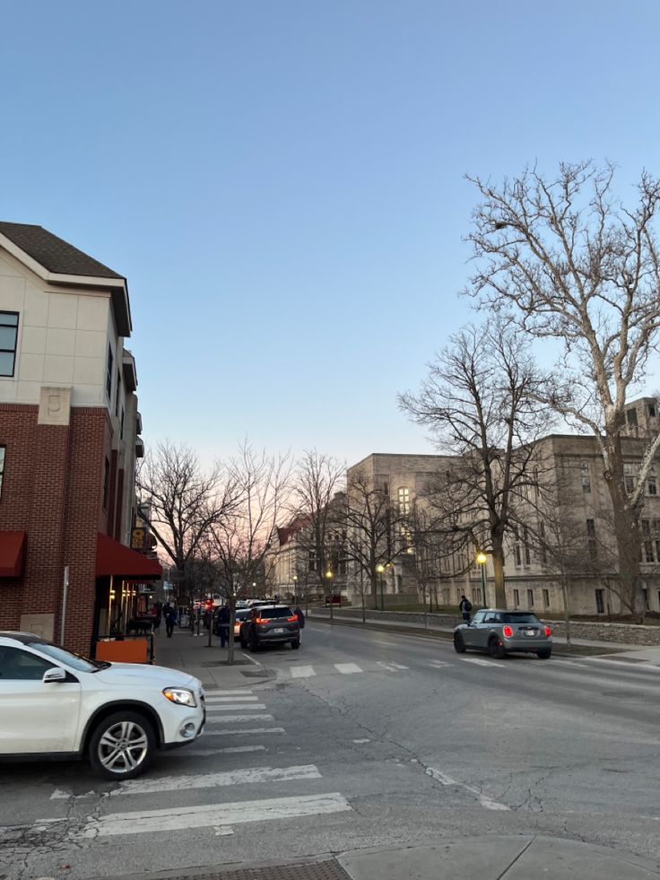 cars are parked on the street in front of buildings