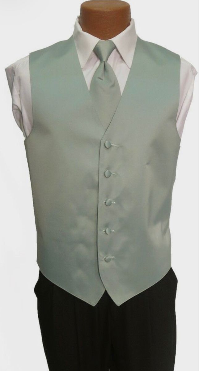 a mannequin wearing a green vest and white shirt with black pants on display