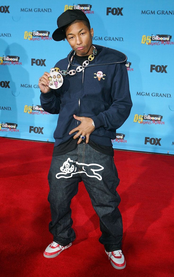 a young man wearing a black hat and blue jacket holding a medal in his right hand