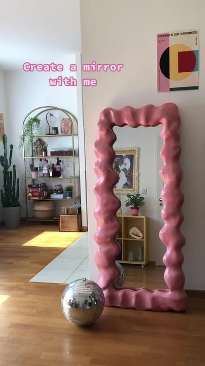 a pink mirror sitting on top of a hard wood floor