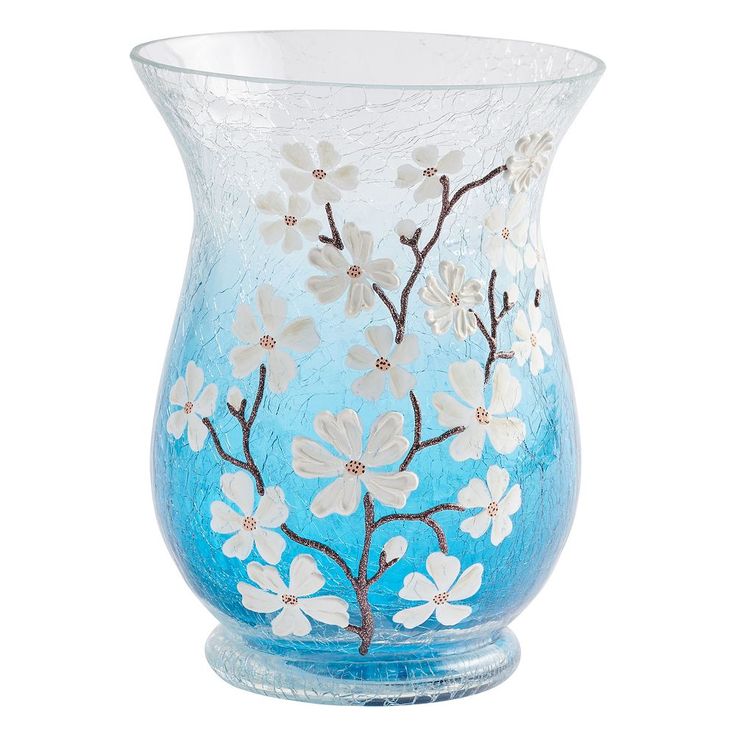 a blue vase with white flowers painted on the outside and inside, sitting against a white background