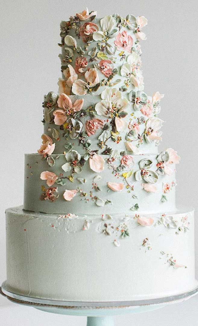 a three tiered white cake with pink flowers on top