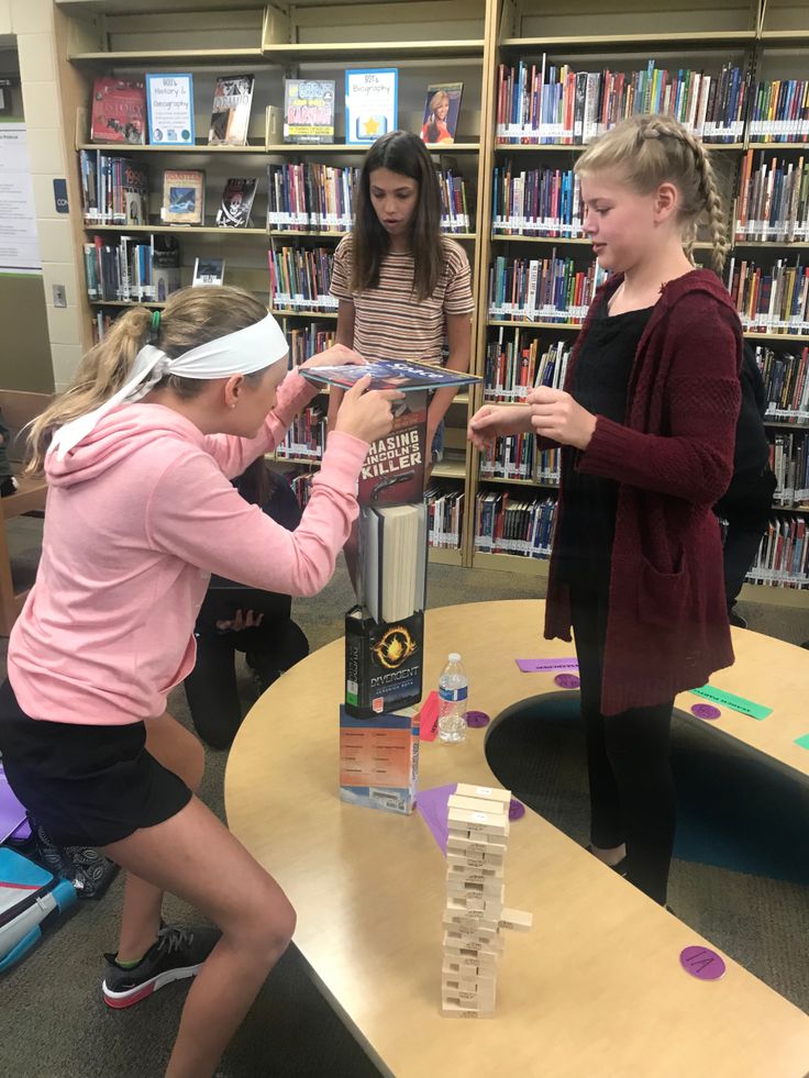 two girls are playing with blocks in the library