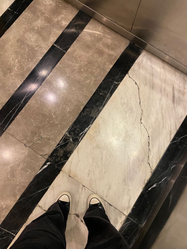 a person standing on an escalator with their feet up in the air and looking down