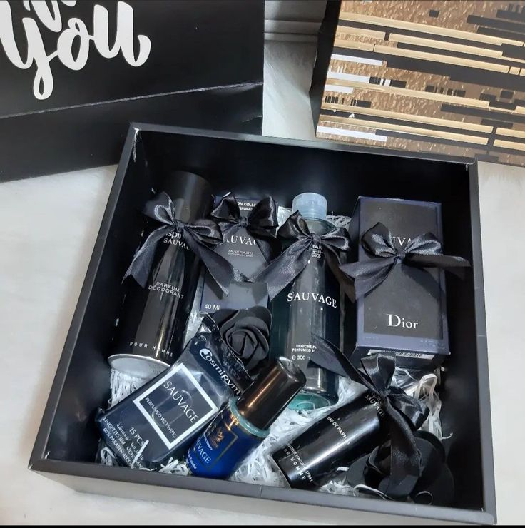 an open black box with personal items in it sitting on a table next to other boxes