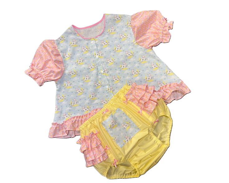 OVER THE MOON DIAPER Shirt Set will be custom made just for you. This little Diaper Shirt set is made from a very nice cotton blend fabrics. Little cows jumping over the moon with pink ruffles featuring yellow, blue and green moons and stars.  Neckline has pink piping and sleeves have matching ruffles and encased elastic.  This darling little diaper shirt snaps down the front. Diaper Cover is pale yellow with matching pink moon/stars.  Ruffles wrap around the hips and are topped with dainty satin bows.  All elastic is encased. Maximum shirt length 26" 🎀  🌼  🌷  🎈  🎀  🌼  🌷  🎈  🎀  🌼   Actual fabric color, lace, and trims may vary slightly from picture. I do my best to recreate this to the original picture. 🎀  🌼  🌷  🎈  🎀  🌼  🌷  🎈  🎀  🌼   🌷  MEASUREMENTS 🌷 maximum size lis Diaper Shirt, Moons And Stars, Green Moon, The Wiggles, Pink Moon, Pink Ruffle, Moon Stars, Diaper Cover, Over The Moon