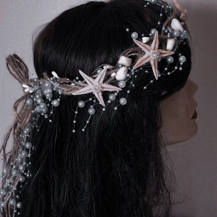 a close up of a woman's head wearing a tiara with starfishs and pearls